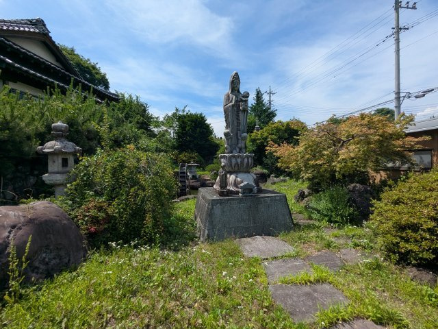 観音像や石燈籠が佇む荘厳なお庭。豊かな緑と歴史ある風情が調和し、深く心癒やされる景観です。