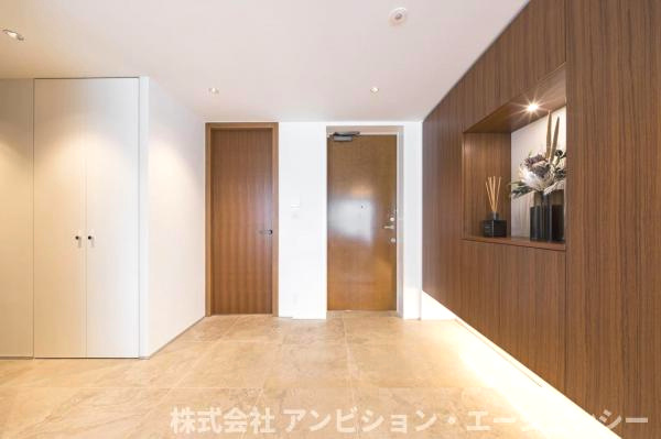 機能と美しさの両立を伝える場合空間を彩る大型壁面収納。間接照明が足元を照らす、上質で開放的な玄関空間