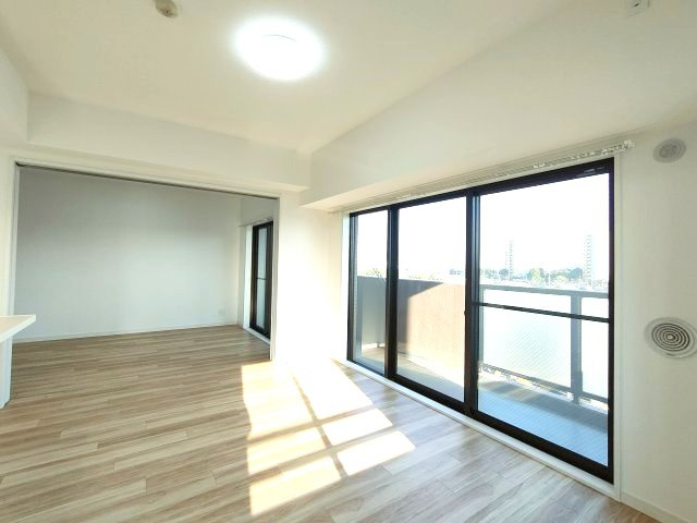 【LDK約12.7帖】　大きな窓があることによって、外との一体感が生まれ、空間をより広く見せる役目を果たしているとともに、窓から見える緑や、外の景色もデザインに取り込まれているかのようです。
