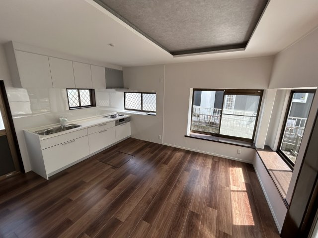 フロアタイル仕上げのリビング。キッチン新調済みで、2面採光の明るい空間です。