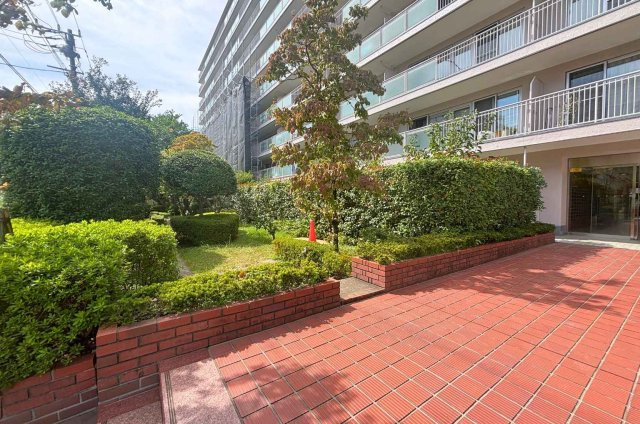マンションの手前には植栽が施されています。通路があり、お子様の遊び場にもなりそうですね。