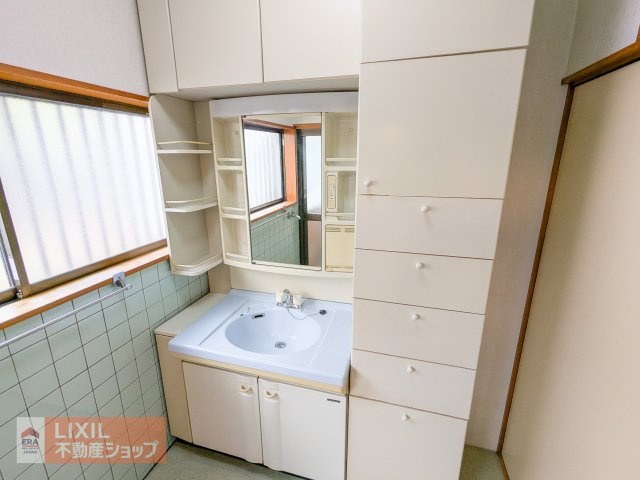 洗面台と収納棚、換気のできる大きな窓があります