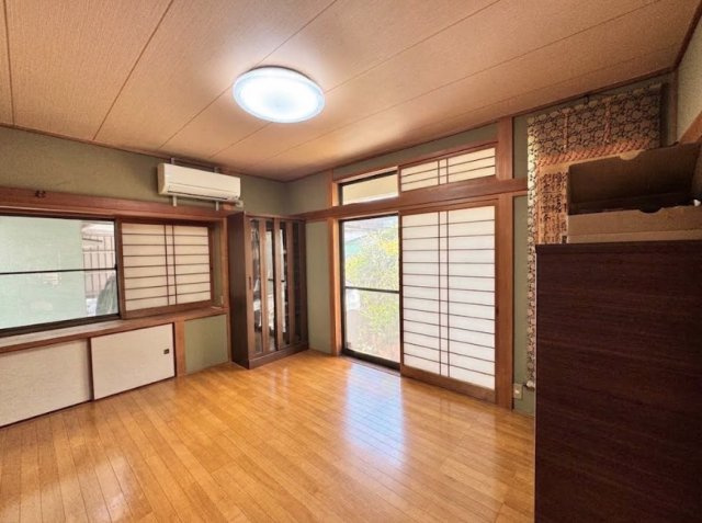 木目のフローリングと障子・木製建具が調和した、和の趣を感じられる洋室です。大きな開口部から光を取り込みやすく、庭の緑を室内から眺められるのも魅力。押入れタイプの収納も備えております。