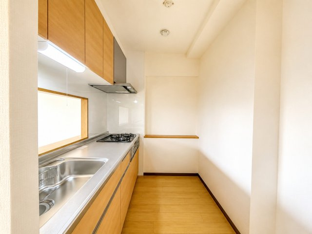 作業スペースにゆとりのあるシステムキッチンです。シンク・調理スペース・コンロがバランスよく配置され、効率的に調理が行えます。収納も上下に確保されており、調理器具や食器をすっきり整理可能です。