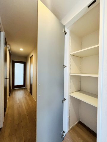 廊下の可動棚収納。高さを調整することで背の高い物もすっぽりおさまります。