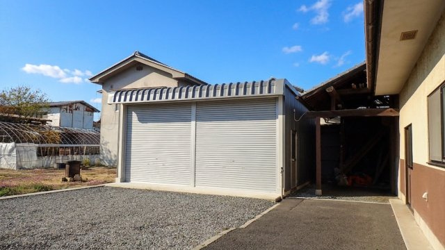 ？シャッターと勝手口を備えた堅牢なつくりのガレージ外観です