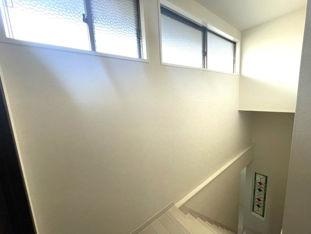 明るい窓から自然光が差し込む開放的な階段スペース。手すり付きで安全性にも配慮。壁面の壁面のデザイン窓が空間のアクセントとなり、上品な雰囲気を演出。毎日の移動も気持ちよく行える、ゆとりある設計。