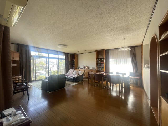 広々としたリビングは、木の温もりを感じるフローリングと造り付け収納が魅力。大きな窓からやわらかな光が差し込み、家族団らんの時間を心地よく演出します。ダイニングスペースもゆったりと使える空間です。