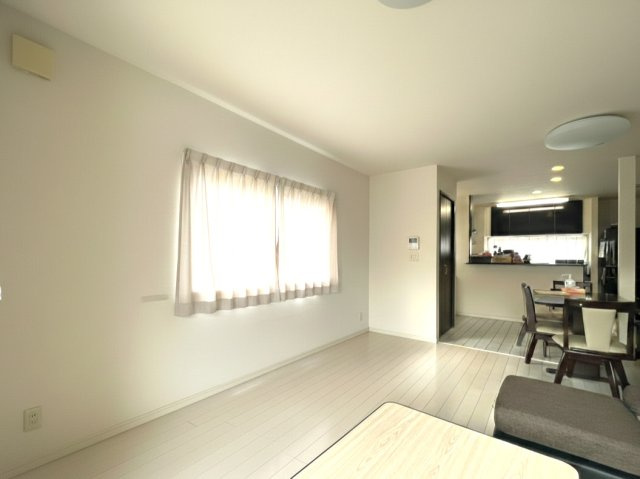 大きな窓からやわらかな光が差し込む明るいリビング。南向きのため日中は照明に頼らず過ごせる心地よい空間です。白を基調とした内装が開放感を演出し、家具のレイアウトもしやすい間取り。