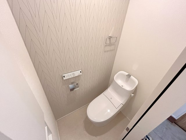 居心地のよい配色のアクセントクロスを使ったトイレです。