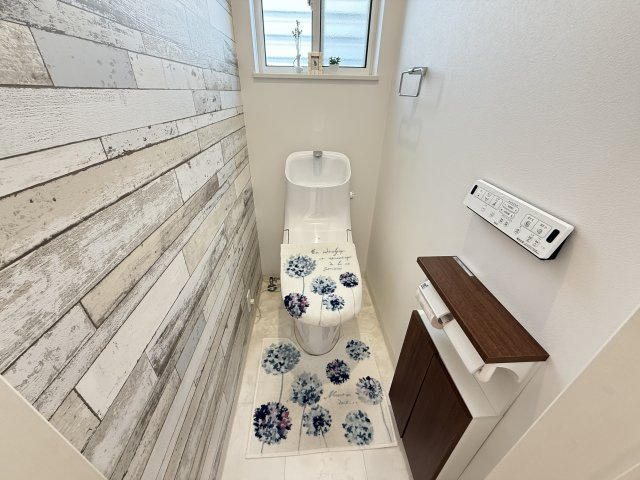 アクセントクロスが印象的な落ち着きのある空間。温水洗浄便座付きで快適に使用できます。小窓付きで明るさと換気を確保。手洗い一体型で使い勝手も良く、来客時にも安心の仕様です。