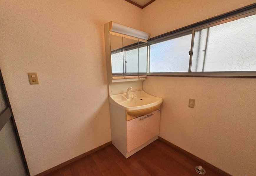 洗面室は清潔感のある明るい空間となっています。三面鏡タイプを採用しており、身だしなみのチェックや収納にも便利です。浴室と隣接した家事動線の良い配置となっており、毎日の生活を快適にしてくれる空間です。