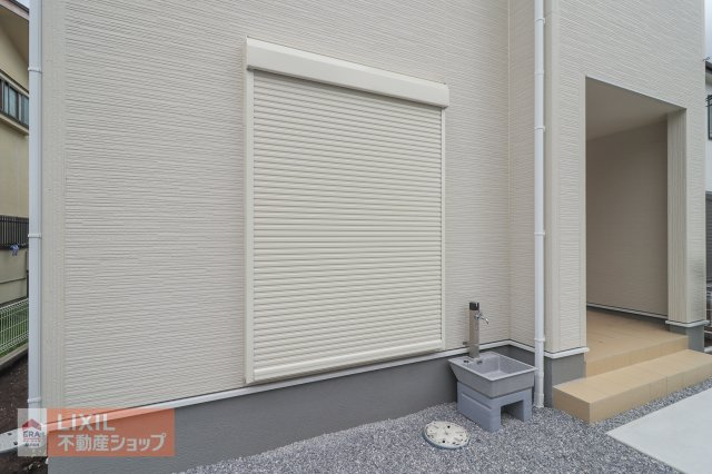 【防犯設備】現地完成写真。1階リビングには雨風の強い日にも役立つ防犯シャッターが外壁にも馴染む色でついています。