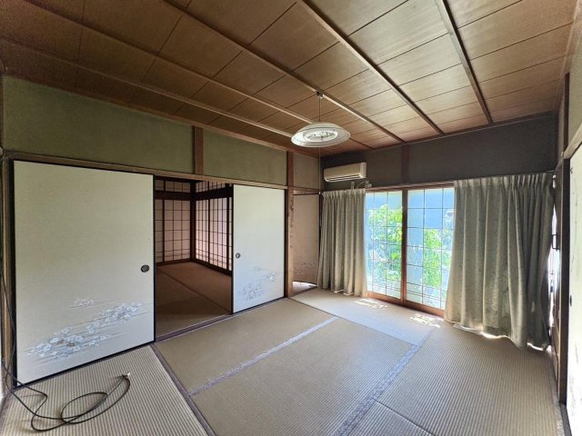 1階中央の和室です。2面の襖を開ければ、隣の和室や縁側とつながる開放的な空間に。障子窓からは、心地よい自然光が差し込みます。エアコン付きで通年快適に過ごせます。