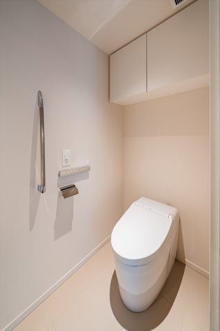 手すりや上部棚が備えられた清潔なトイレです！ペーパーの予備や掃除用品もスマートに収まります！