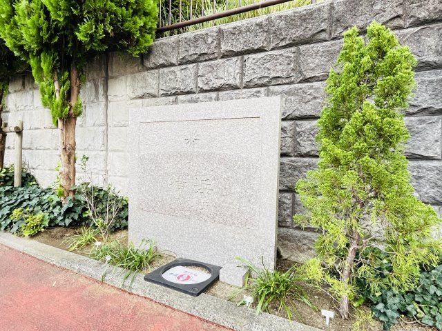 【館名板】緑に囲まれたエントランスに設けられた館名板。穏やかな街並みに調和するデザインです。