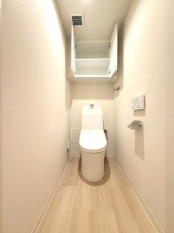 【トイレ】　棚が備え付けられたトイレなので、収納にも困りません。トイレは温水洗浄便座付です。