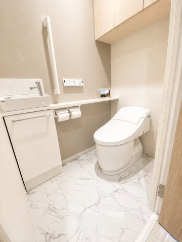清潔感があり足元の広いトイレは手洗い、収納付き。もちろん洗浄機能つき暖房便座です