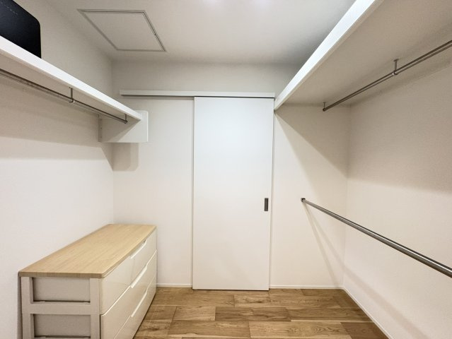 衣類や荷物をたっぷり収納できる、ウォークインクローゼット。左右にハンガーパイプと棚が設置され、洋服を掛けたまま整理できるほか、収納ケースも保管可能。キッチンと洗面所への2WAYで出入り可能な設計です。
