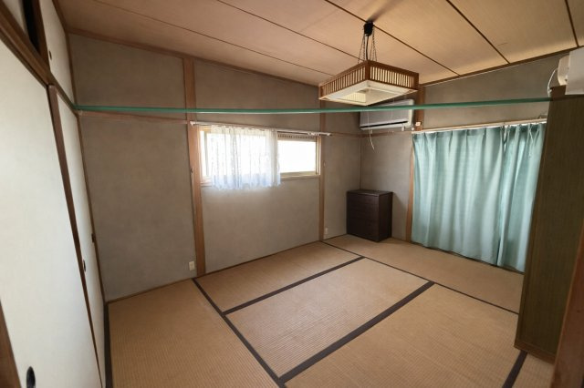 畳の温もりを感じられる落ち着いた和室。大きな窓から自然光が差し込み、明るく開放感のある空間です。押入収納も備わっており、布団や季節物をしっかり収納可能。エアコン付きで快適性も確保されています。