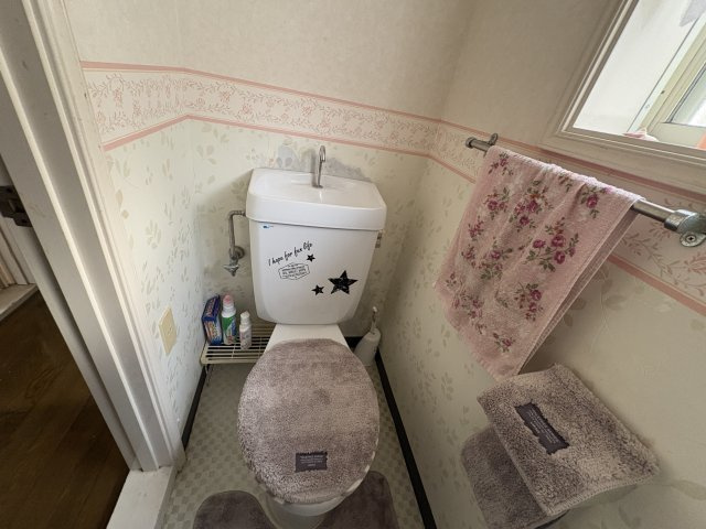 コンパクトながら使い勝手の良いトイレ空間。窓があり、自然換気ができるため快適に利用できます。壁面にはタオル掛けや小物を置けるスペースもあり、日常使いしやすい設計です。