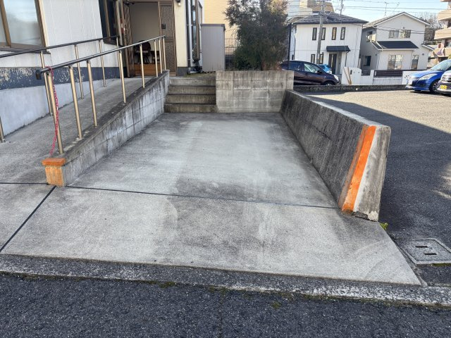 建物横に確保されたコンクリート舗装の駐車スペース。前面道路からの進入もスムーズで、切り返しもしやすい形状です。住居兼事務所としての利用にも適しています。　