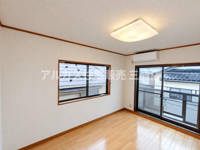 ナチュラルな木目のフローリングが心地よい洋室。エアコンが設置されており、年間を通して快適に過ごせます。
