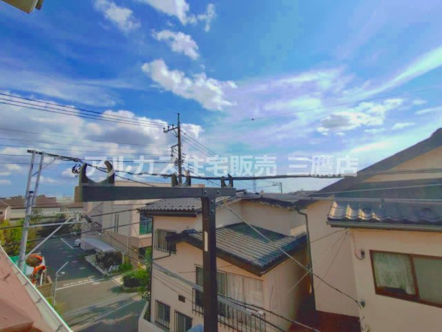 バルコニーから見た周辺の街並み。道路や住宅の屋根越しに、空が広がる様子を確認できます。