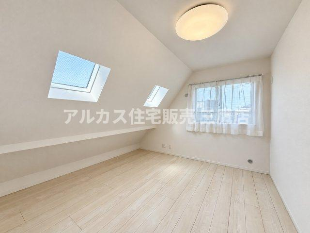 傾斜天井とトップライト（天窓）が特徴的な洋室。高い位置からやわらかな光が差し込む個性的で明るいお部屋です。
