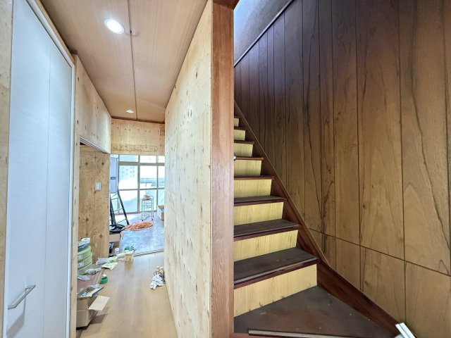 廊下と階段がコンパクトにまとまった動線の良い空間。内装を整えることで明るくすっきりとした印象に仕上がり、移動のしやすさも向上します。すでに階段下収納も確保されており、日用品や資材の整理にも便利。