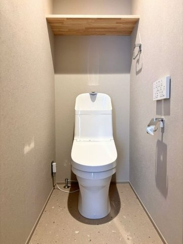 シンプルで洗練されたトイレスペース。収納棚が空間のアクセントとなり、実用性と意匠性を両立しています。