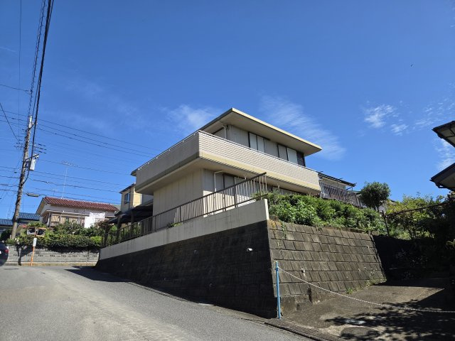 高台に位置する開放感のある売地。周囲を見渡せる眺望が魅力で、陽当たり・通風も期待できる立地です。現況は建物付きですが、建替え用地として理想の住まいづくりをご検討いただけます。