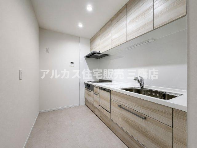 上質な木目デザインのシステムキッチン。壁付けタイプで作業スペースを広く確保できます。