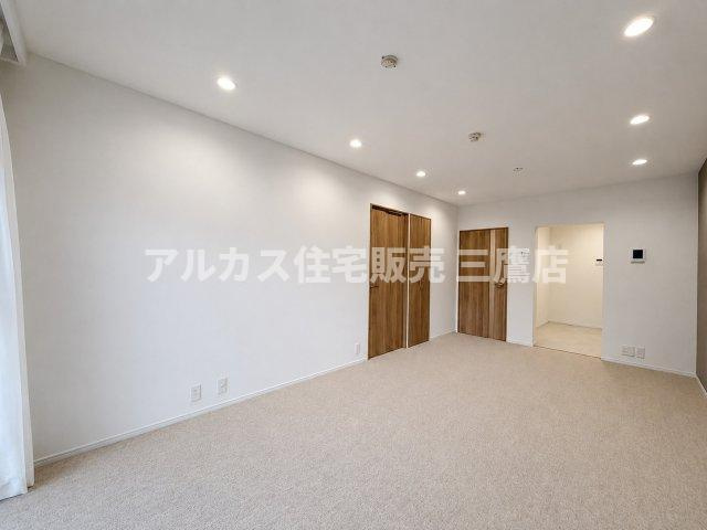 白を基調とした壁面と木目調ドアのコントラストが美しい、広々としたリビング空間です。