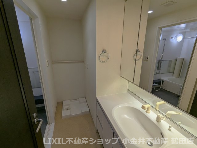 洗面室。洗濯機置き場、洗面台、リネン庫がございます