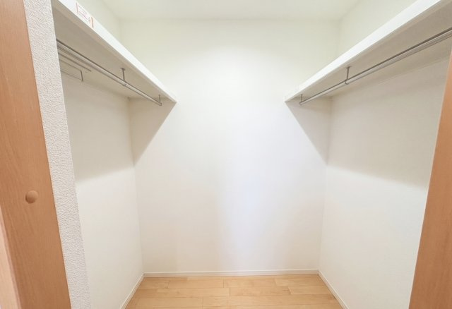 広々としたウォークインクローゼットです。左右にハンガーパイプが設けられており、洋服を整理しやすく取り出しもスムーズです。収納力を確保することで居室を広く使えるため、すっきりとした空間を実現できます。