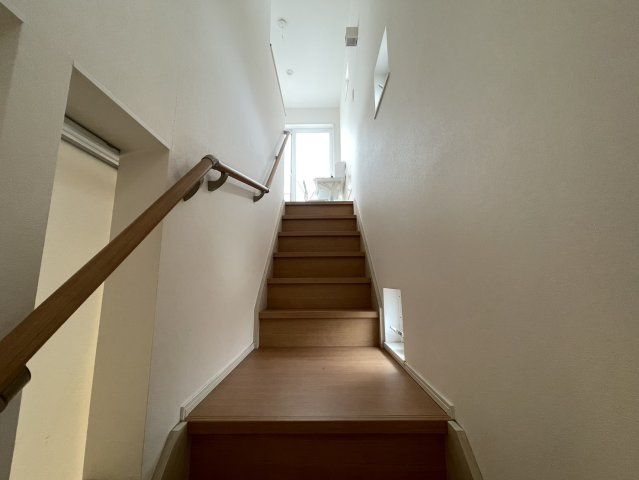 手すり付きで昇り降りしやすい階段は、窓から自然光が差し込む明るい設計です。シンプルなデザインで圧迫感が少なく、毎日の移動も快適です。壁面を広く確保しているため空間全体がすっきりとした印象です。