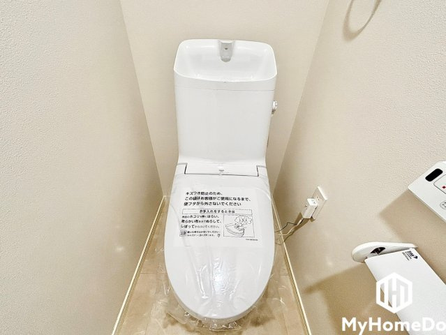 清潔感のある明るいレストルーム。手洗いボウル付きのタンクと壁付けリモコン完備で使い勝手も良好です。
