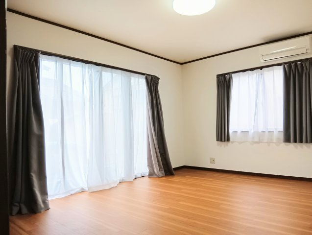 白い壁とナチュラルな木目フローリングが調和した明るいLDK。大きな掃き出し窓と腰窓による2面採光。
