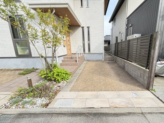 駐車スペースはゆとりのある広さを確保しており、お車の出し入れもスムーズ。玄関までの動線が短く、雨の日のお買い物や荷物の運搬にも便利です。美しく整備されたアプローチと植栽が住まいの印象を引き立てます。　
