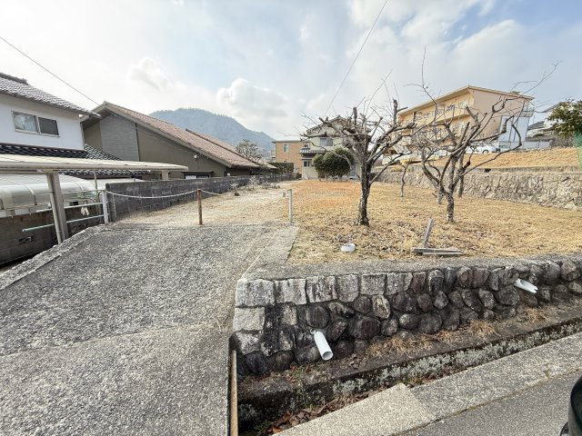 前面道路と敷地入口付近の様子です。第一種低層住居専用地域に位置しており周辺は静かな住宅環境が広がる落ち着いた街並み。広い敷地を活かして平屋住宅や庭付きの住まいなどゆとりある住まいづくりを検討できる土地