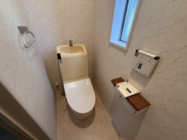 落ち着いた雰囲気のトイレ空間。温水洗浄便座付きのため、年中快適に・衛生的にお使いいただけます。