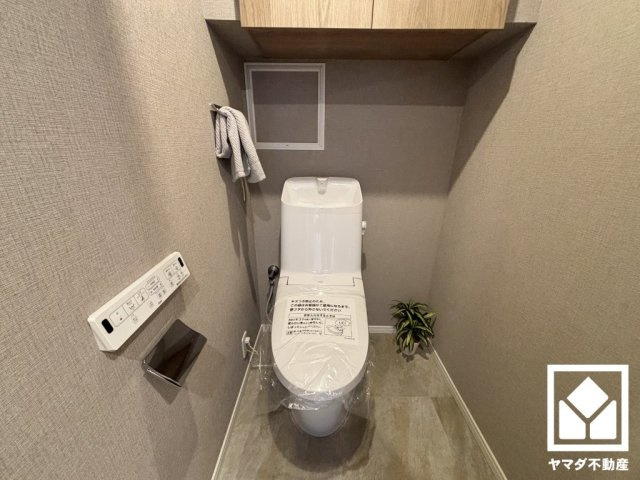 明るく清潔感溢れるトイレです。温水洗浄便座付きで、季節を問わずいつでも温かい便座をお使いいただけます。トイレットペーパーのストックや消耗品置き場などとしてお使いいただける吊戸棚がございます。