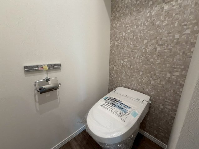 デザイン性の高いアクセントクロスが施された落ち着きあるトイレ空間。温水洗浄便座などの快適設備を備え、手洗い器も付いているため毎日の利用がより衛生的でスマートに行えます！