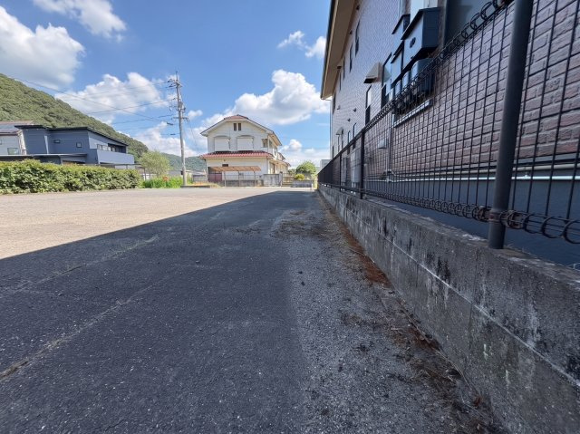 敷地横から確認できる現地の様子です。前面道路との高低差も少なく、建築計画が立てやすい土地です。周辺には住宅が建ち並びながらも圧迫感が少なく、落ち着いた住環境の中で快適な暮らしが期待できます。