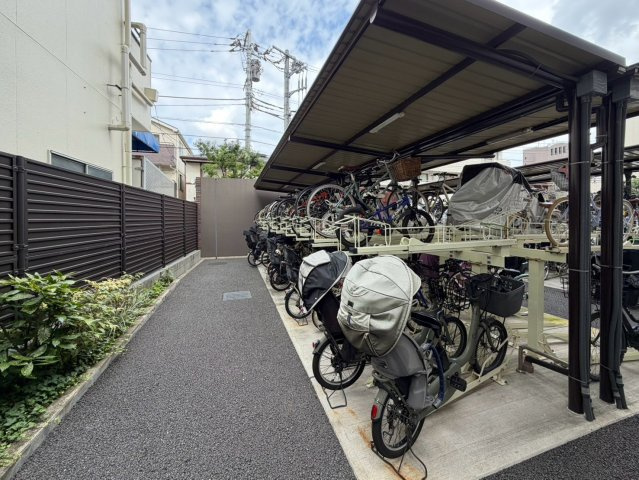 敷地内には屋根付きの駐輪スペースを確保。2段式ラックを備え、複数台の自転車を効率よく収容できる設計です。日常の使いやすさにも目を向けた共用設備が整っています。