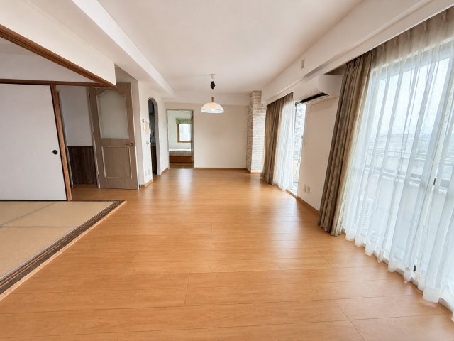 広々としたリビングダイニングは、大きな掃き出し窓から自然光がたっぷり差し込む開放感のある空間です。フローリング仕様でお手入れもしやすく、ナチュラルな色合いが落ち着いた雰囲気を演出しています。