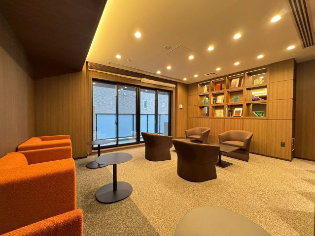 【ラウンジ9】木調の壁にアーティスティックな配色の家具。ライトアップされた飾り棚が印象的。