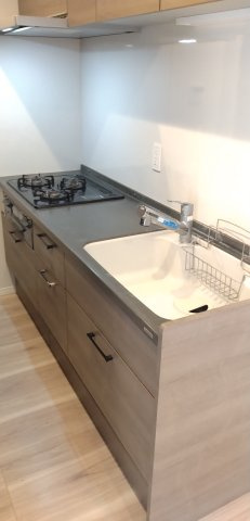 上部に吊り戸棚が設置された、浄水器付きのシステムキッチンです