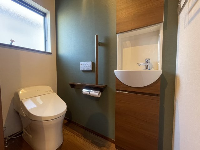 落ち着いた色合いのアクセントクロスが上質な雰囲気を演出するトイレ空間。窓付きで明るく換気もしやすく、いつも快適に保てます。独立した手洗い器は衛生的で使い勝手も良好。毎日気持ちよく使えます。